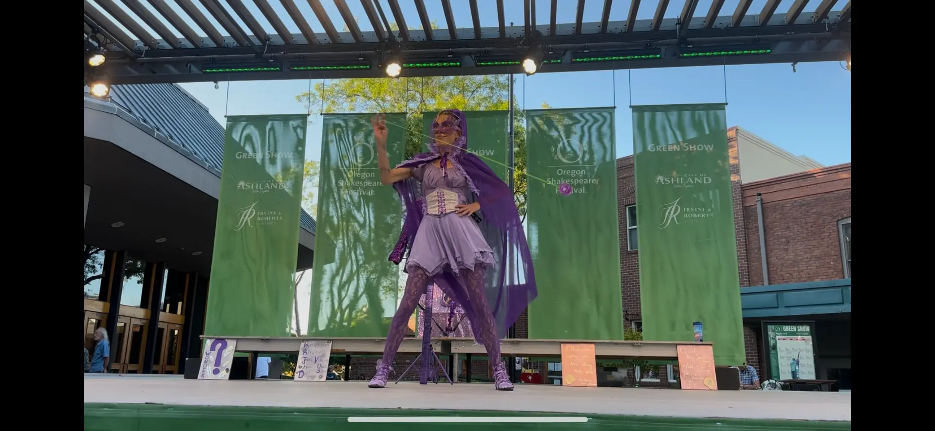 Jenifer Joy in purple cape throwing a yo-yo on the Oregon Shakespeare Festival Green Show stage