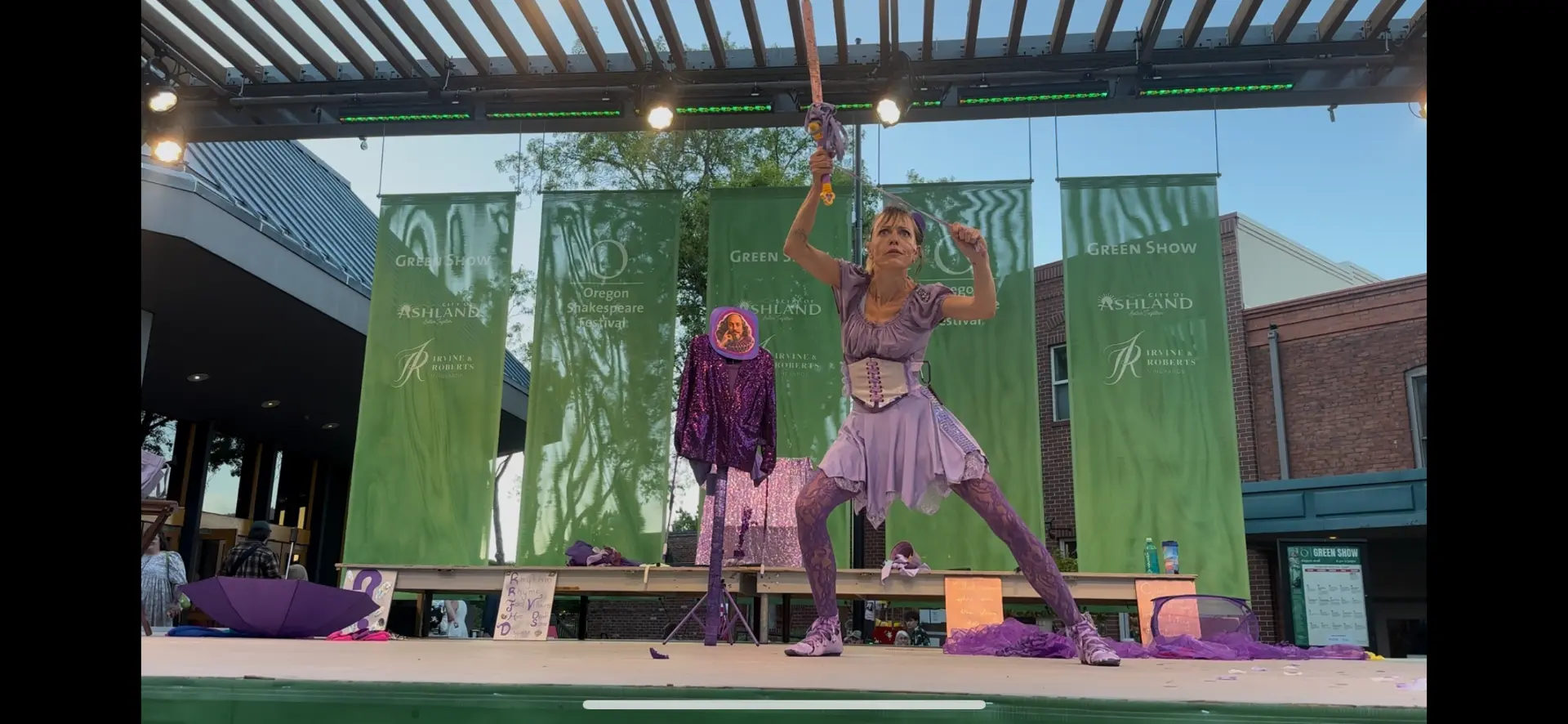 Jenifer Joy in a wide stance raising a yo-yo sword overhead during The Merry Yo-Yo of Windsor